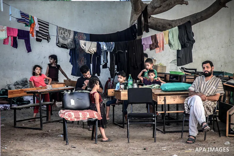 Displaced Palestinians gather at an United Nations (UN) school in Jabalia in the northern Gaza Strip, where they found refugee with their families after fleeing their homes in areas under heavy Israeli bombardment in the...