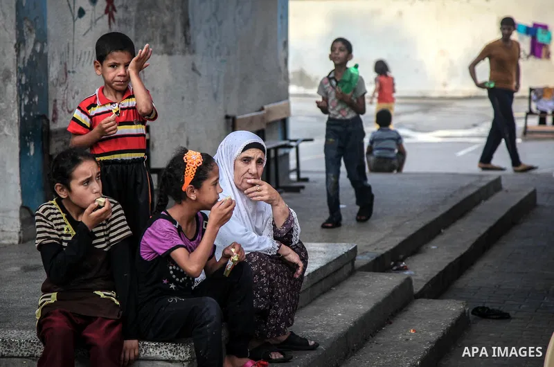 Displaced Palestinians gather at an United Nations (UN) school in Jabalia in the northern Gaza Strip, where they found refugee with their families after fleeing their homes in areas under heavy Israeli bombardment in the...