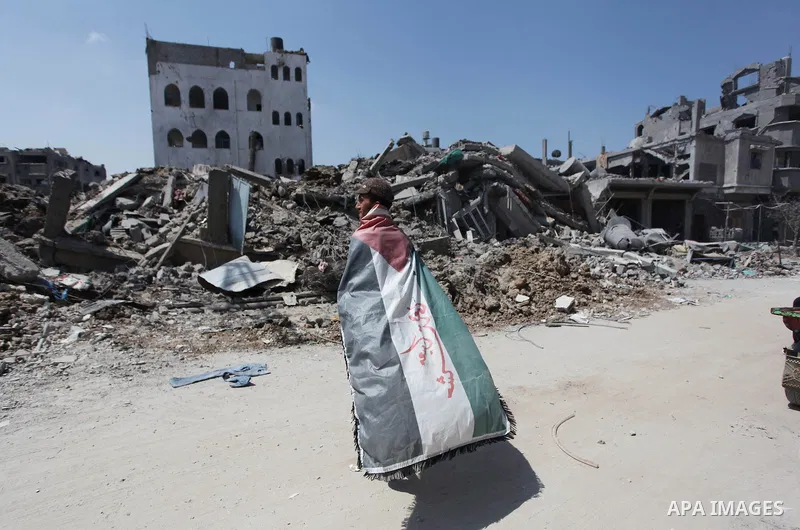 A Palestinian man reacts as he looks at the rubble of destroyed buildings and homes in the Shejaiya residential district of Gaza City on July 28, 2014. on the beginning of the Muslim Eid festival ending the month-long fa...