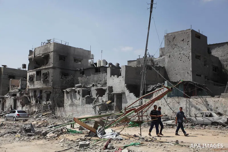 Palestinian children play near a damaged mini ferris wheel in the wartorn Shejaiya district of Gaza City on July 28, 2014 on the first day of Eid al-Fitr holiday. The Muslim three-day Eid al-Fitr festival, that marks the...