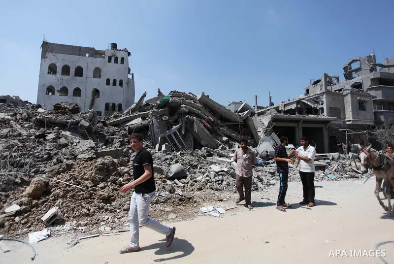 A Palestinian man reacts as he looks at the rubble of destroyed buildings and homes in the Shejaiya residential district of Gaza City on July 28, 2014. on the beginning of the Muslim Eid festival ending the month-long fa...
