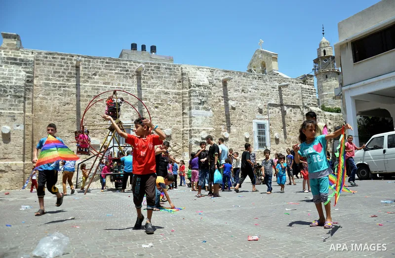 Displaced Palestinian children play as they are celebrating the Eid al-Fitr festival at the Saint Porphyrios church, in Gaza city on July 28, 2014. Security Council agreed on a statement urging Israel, Palestinians and I...