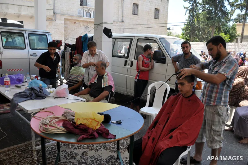 Displaced Palestinian muslims gather at the Saint Porphyrios church, in Gaza city on July 28, 2014. during the Muslim holiday of Eid al-Fitr at a cemetery. The United Nations Security Council agreed on a statement urging...