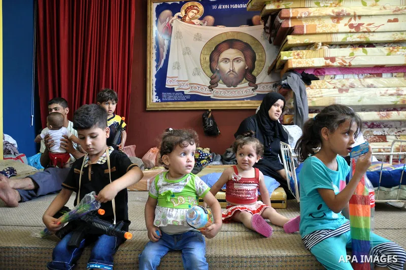 Displaced Palestinian muslims gather at the Saint Porphyrios church, in Gaza city on July 28, 2014. during the Muslim holiday of Eid al-Fitr at a cemetery. The United Nations Security Council agreed on a statement urging...