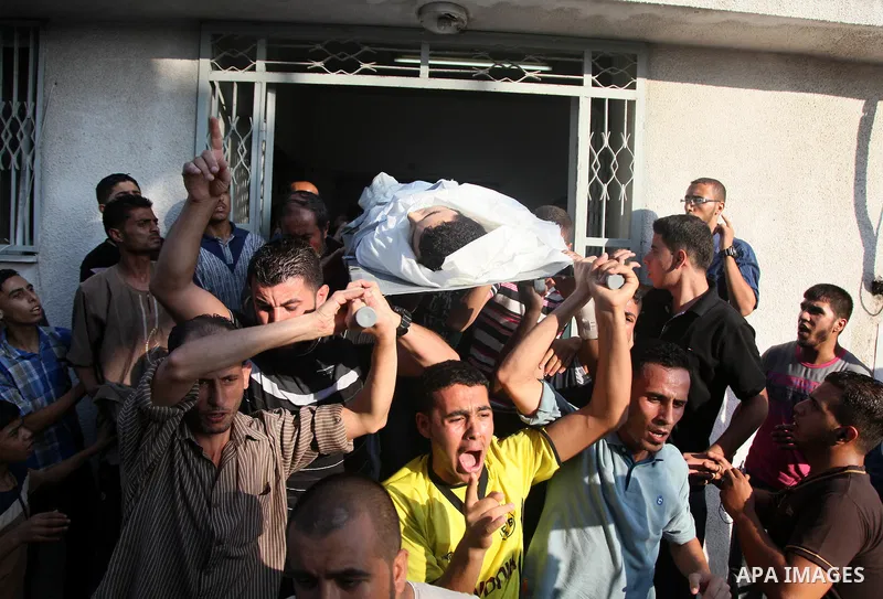 Palestinians chant slogans while carrying the body, who was killed along with 9 other people, all but one of them children, in an explosion at a park at the Shati refugee camp, in the northern Gaza Strip, Monday, July 28...