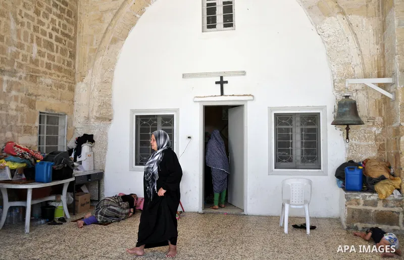 Displaced Palestinian muslims gather at the Saint Porphyrios church, in Gaza city on July 28, 2014. during the Muslim holiday of Eid al-Fitr at a cemetery. The United Nations Security Council agreed on a statement urging...
