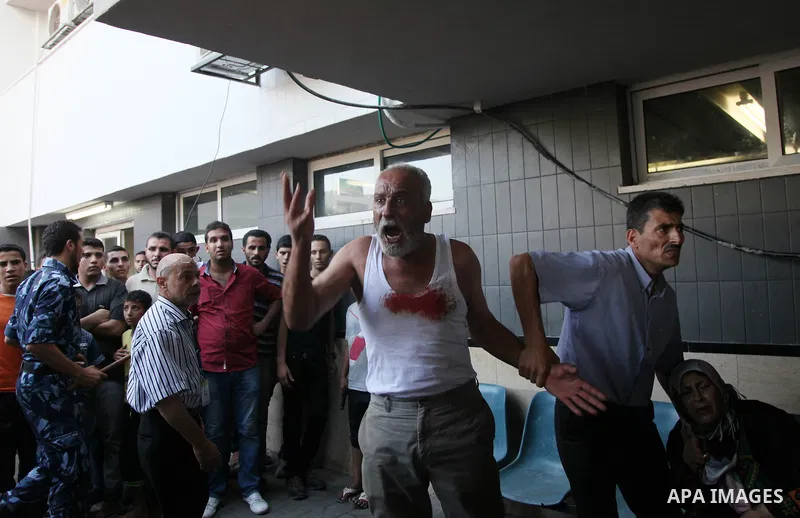 A Palestinian man reacts after an explosion that medics said killed eight children and two adults, and wounded 40 others at a public garden, at the Shifa hospital in Gaza City July 28, 2014. At least 10 Palestinians are...