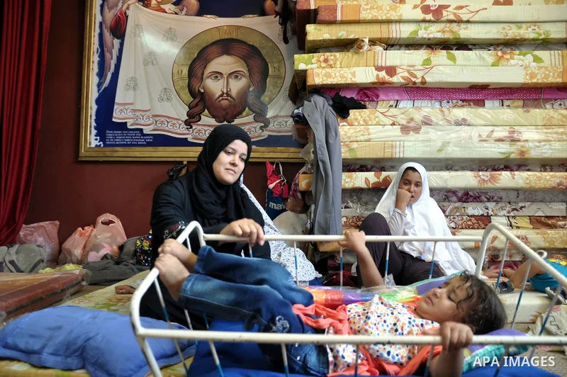 Displaced Palestinian muslims gather at the Saint Porphyrios church, in Gaza city on July 28, 2014. during the Muslim holiday of Eid al-Fitr at a cemetery. The United Nations Security Council agreed on a statement urging...
