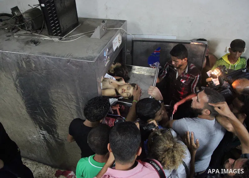 Palestinian men mourn over the bodies of six children who were killed in a explosion in a public playground in the beachfront Shati refugee camp in Gaza City on July 28, 2014. At least 10 Palestinians are killed and more...
