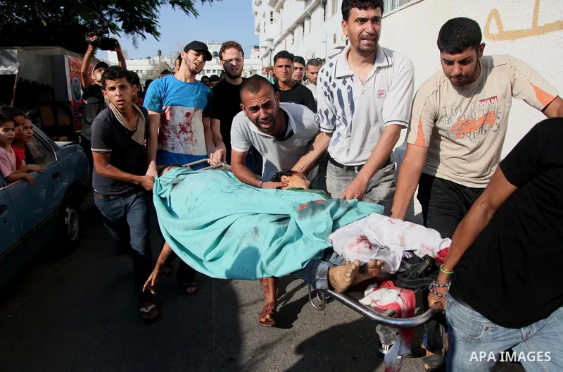Palestinian men mourn over the bodies of six children who were killed in a explosion in a public playground in the beachfront Shati refugee camp in Gaza City on July 28, 2014. At least 10 Palestinians are killed and more...