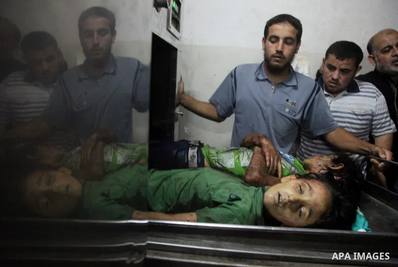 Palestinian men mourn over the bodies of six children who were killed in a explosion in a public playground in the beachfront Shati refugee camp in Gaza City on July 28, 2014. At least 10 Palestinians are killed and more...