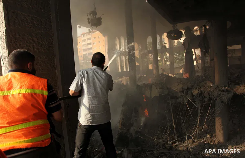 Palestinian firefighters extinguish fire at a mosque after it was hit by an Israeli air strike, on July 29, 2014, in Gaza City. Bloodshed in and around Gaza surged with strikes killing at least 13 Palestinians, a day aft...