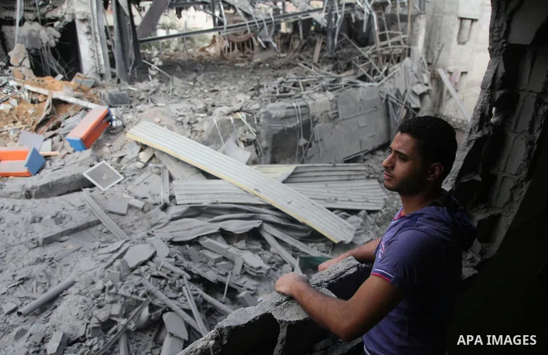 Palestinian neighbours of the Al Aqsa television station dig through rubble after the building was destroyed in an Israeli strike in central Gaza City on July 29, 2014. Following two nights without air strikes, the viole...
