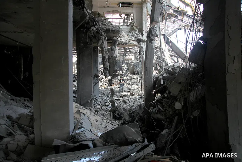 A foreign journalist walks through the rubble of the Al Aqsa television building after it was destroyed in an Israeli strike in central Gaza City on July 29, 2014. Following two nights without air strikes, the violence r...
