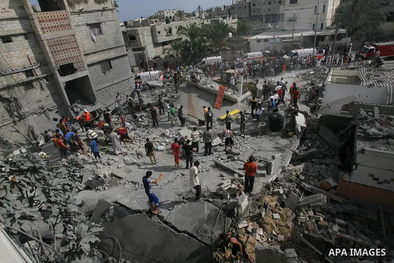 Palestinian rescue workers search for victims as people gather atop the remains of a house, which witnesses said was destroyed in an Israeli air strike, in Khan Younis in the southern Gaza Strip July 29, 2014. Israel's m...