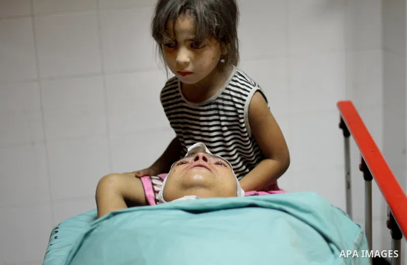 Two Palestinians injured in Israeli air strikes wait outside the Khan Yunis hospital in the southern Gaza Strip on July 29, 2014. The fighting between Israeli troops and Hamas militants raged on unabated with scores more...