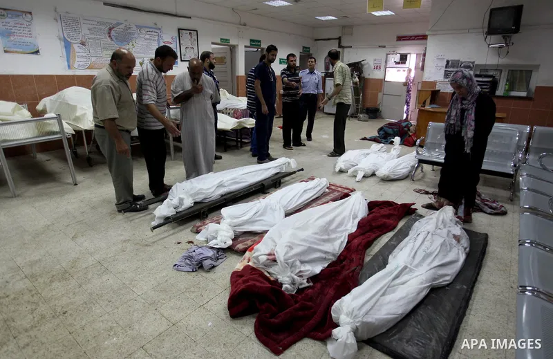 Palestinian medical staff look at bodies, killed the night before in Israeli air strikes, at the Khan Yunis hospital on July 29, 2014. The fighting between Israeli troops and Hamas militants raged on unabated with scores...