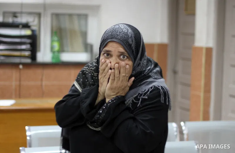 Palestinians relative reacts at Nasser hospital after members of thier family were killed in an Israeli air strike on their house in Khan Yunis, in the southern Gaza Strip, on July 29, 2014. Photo by Ramadan El-Agha