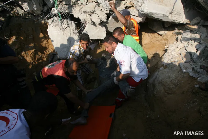 Palestinian rescue workers carry the body of a member of Duheir family, after removing it from under the rubble of a building destroyed by an Israeli air strike in Rafah on July 29, 2014, in the southern of Gaza strip. B...
