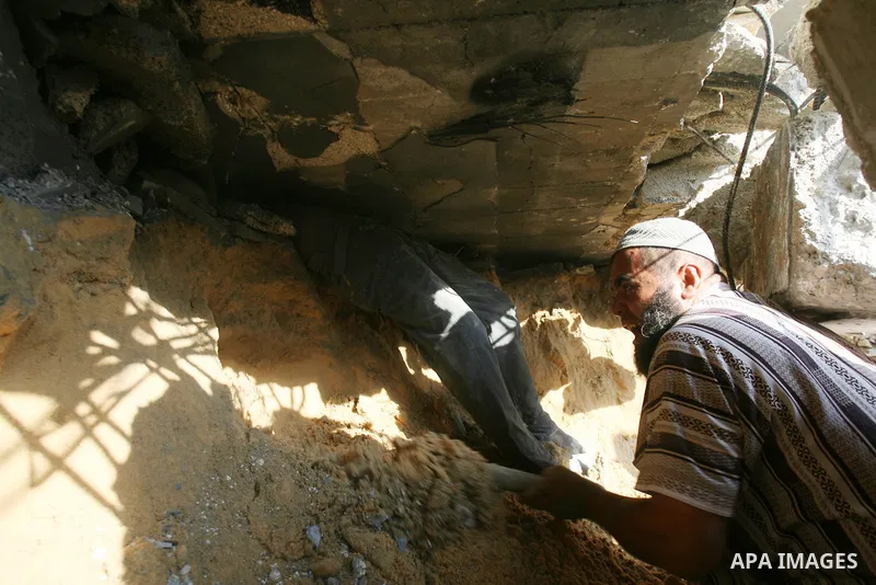 Palestinian rescue workers search for victims in a building destroyed by an Israeli air strike in Rafah on July 29, 2014, in the southern of Gaza strip. Bloodshed in war-torn Gaza surged with dozens more Palestinians kil...