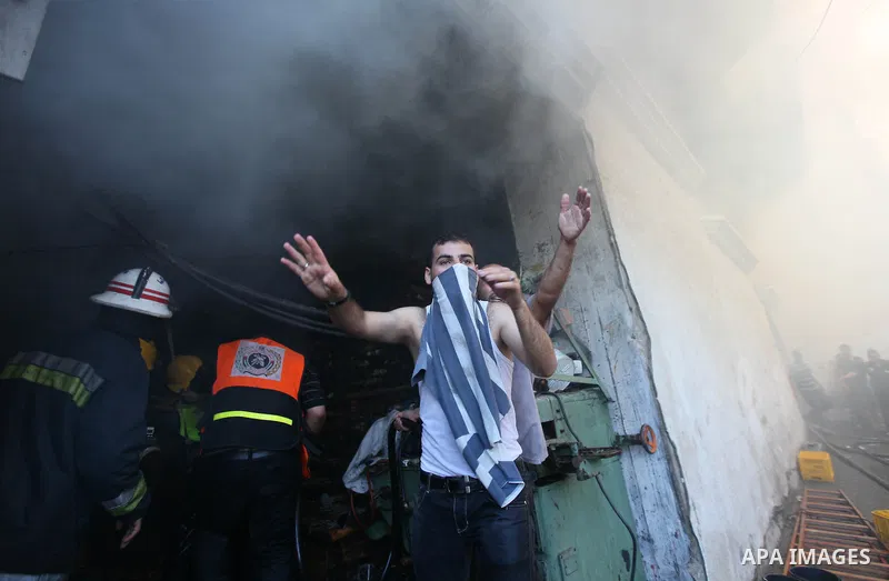 Palestinians try to put out a building on fire following several Israeli strikes on Gaza City on July 30, 2014. So far, according to Palestinian medics, 1,283 people have been killed and more than 7,170 wounded since the...