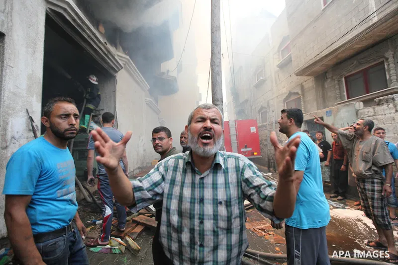 Palestinians try to put out a building on fire following several Israeli strikes on Gaza City on July 30, 2014. So far, according to Palestinian medics, 1,283 people have been killed and more than 7,170 wounded since the...