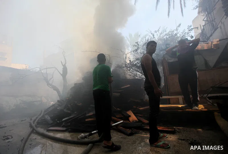 Palestinians try to put out a building on fire following several Israeli strikes on Gaza City on July 30, 2014. So far, according to Palestinian medics, 1,283 people have been killed and more than 7,170 wounded since the...
