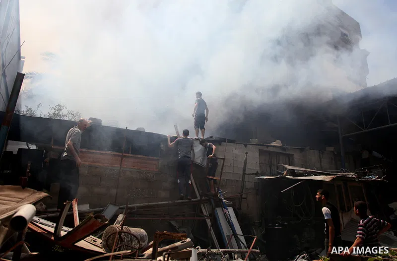 Palestinians try to put out a building on fire following several Israeli strikes on Gaza City on July 30, 2014. So far, according to Palestinian medics, 1,283 people have been killed and more than 7,170 wounded since the...
