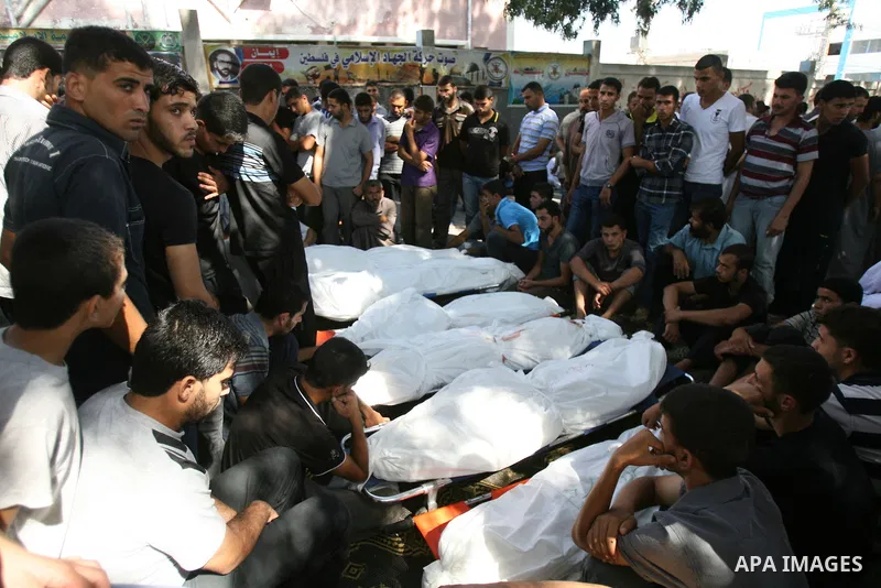 Palestinian mourn over the bodies of ten members of the al-Astal family, that were killed in an Israeli air strike on their homes, during their funeral in Khan Yunis in the southern Gaza Strip on July 30, 2014. Israeli b...