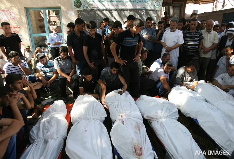 Palestinian mourn over the bodies of ten members of the al-Astal family, that were killed in an Israeli air strike on their homes, during their funeral in Khan Yunis in the southern Gaza Strip on July 30, 2014. Israeli b...