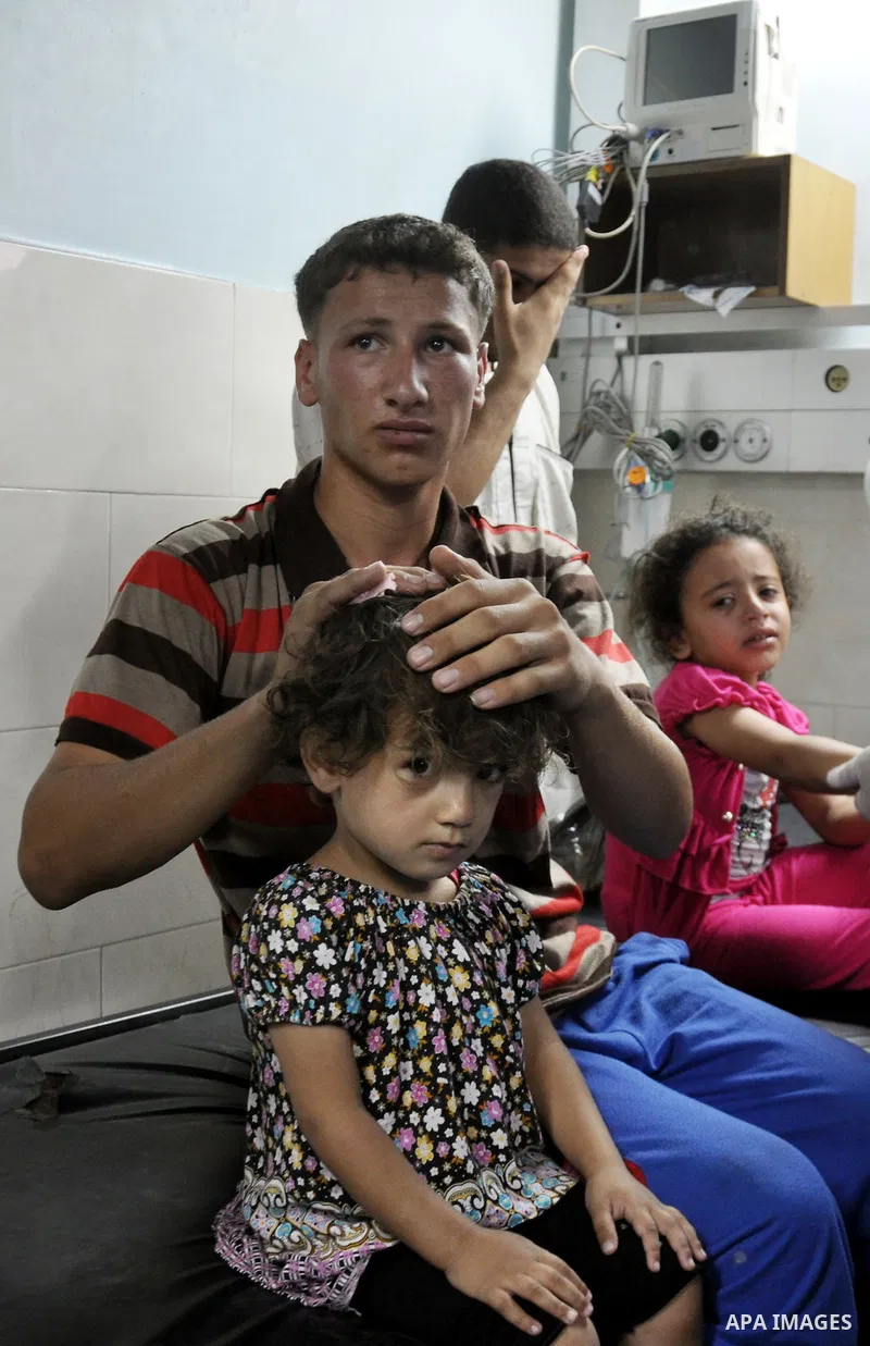 Palestinian medics treat children for their injuries caused by an Israeli strike at a house, at the El-Shifa hospital in Gaza City, Wednesday, July 30, 2014. Several Israeli tank shells slammed into the crowded U.N. scho...