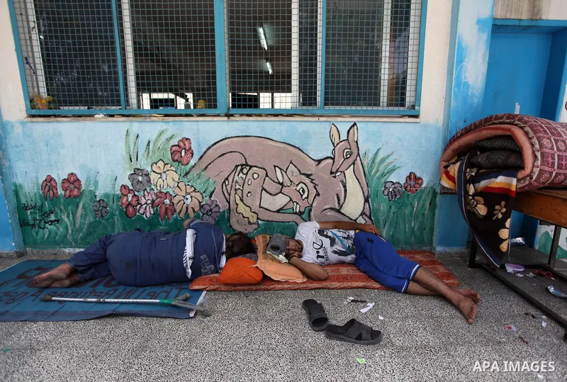 Displaced Palestinian children rest at the Abu Hussien UN school in the Jabalia refugee camp in the northern Gaza Strip after the area was hit earlier in the morning by Israeli shelling on July 30, 2014. Israeli bombardm...