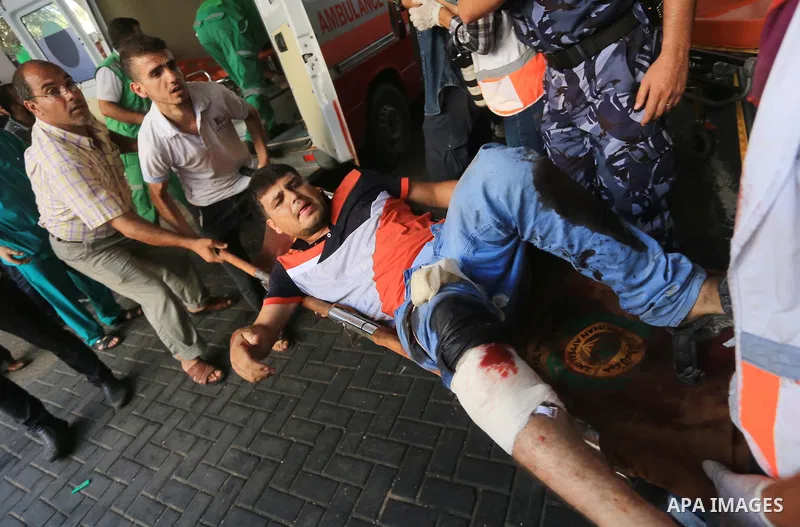 Palestinian medics wheel a wounded man, following an Israeli Strike in Shijaiyah neighborhood, to the emergency room of the Shifa Hospital, in Gaza City, Wednesday, July 30, 2014. Photo by Mohammed Asad