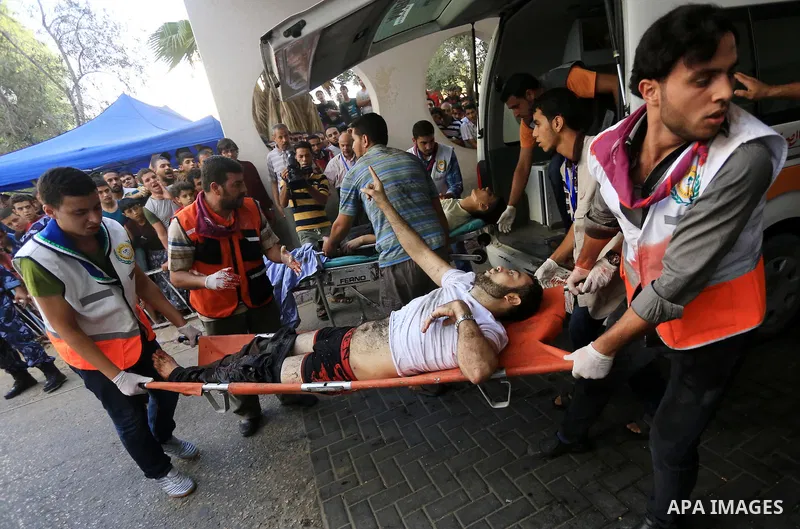 Palestinian medics wheel a wounded man, following an Israeli Strike in Shijaiyah neighborhood, to the emergency room of the Shifa Hospital, in Gaza City, Wednesday, July 30, 2014. Photo by Mohammed Asad