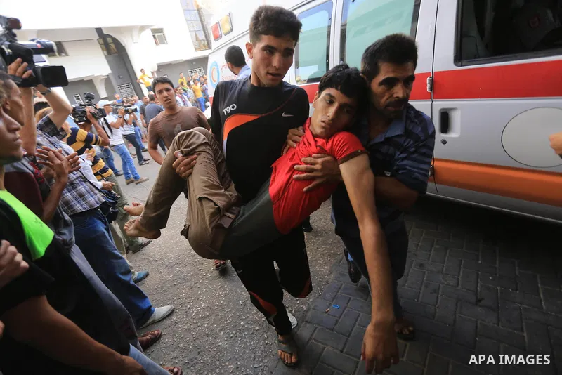 Palestinian medics wheel a wounded man, following an Israeli Strike in Shijaiyah neighborhood, to the emergency room of the Shifa Hospital, in Gaza City, Wednesday, July 30, 2014. Photo by Mohammed Asad