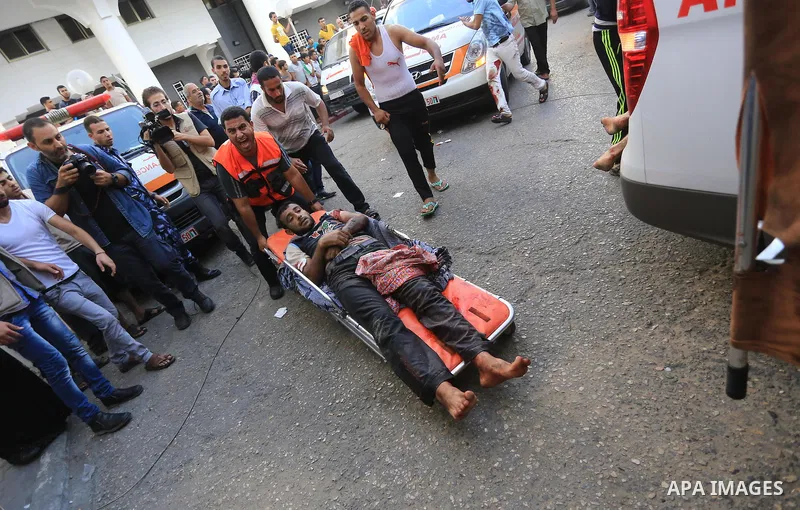 Palestinian medics wheel a wounded man, following an Israeli Strike in Shijaiyah neighborhood, to the emergency room of the Shifa Hospital, in Gaza City, Wednesday, July 30, 2014. Photo by Mohammed Asad