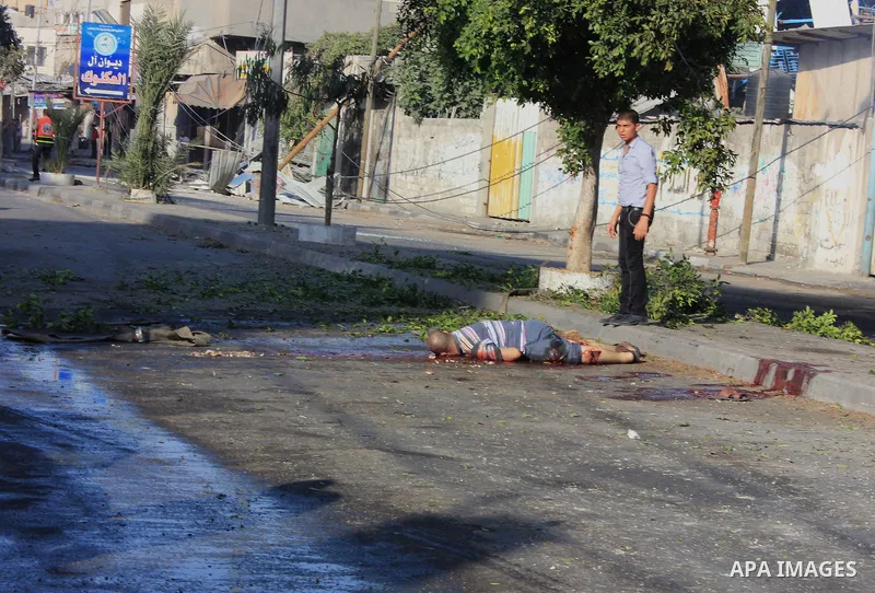 A Palestinian lays on the ground following an Israeli Strike in Shijaiyah neighborhood, eastern Gaza City, Wednesday, July 30, 2014. . Photo by Omar Abed