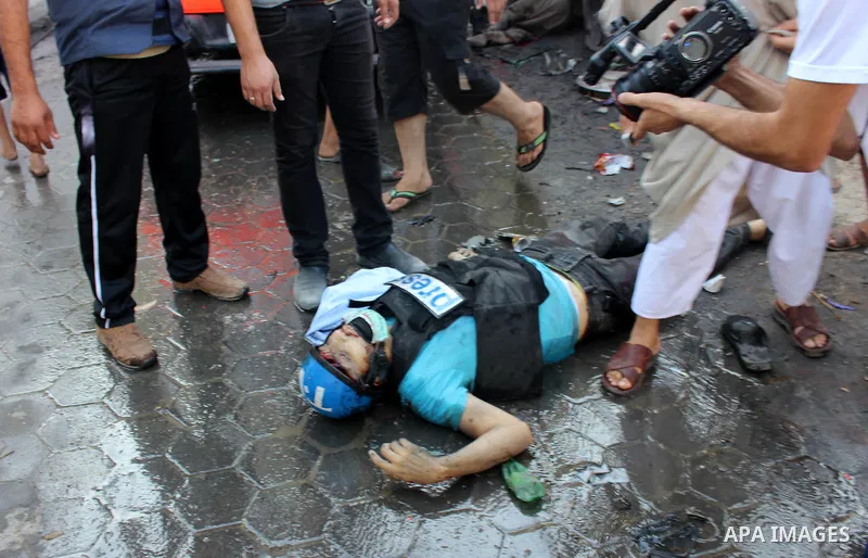 A Palestinian Journalist lays on the ground following an Israeli Strike in Shijaiyah neighborhood, eastern Gaza City, Wednesday, July 30, 2014. . Photo by Omar Abed