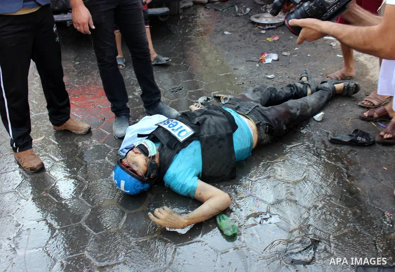 A Palestinian Journalist lays on the ground following an Israeli Strike in Shijaiyah neighborhood, eastern Gaza City, Wednesday, July 30, 2014. . Photo by Omar Abed