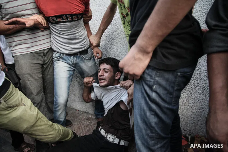 Palestinians cry after identifying their loved one, killed on an Israeli strike in Shijaiyah neighbourhood, at the morgue of Gaza City's Shifa hospital, Wednesday July 30, 2014. Israeli strikes hit the crowded shopping a...