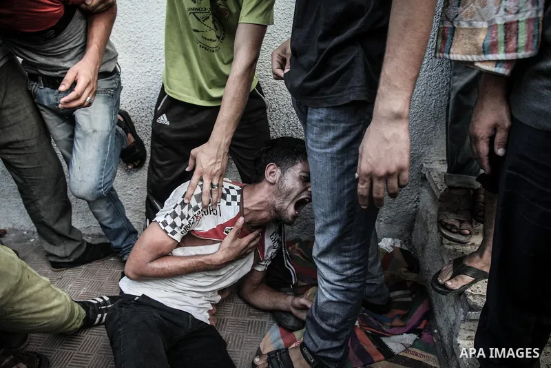 Palestinians cry after identifying their loved one, killed on an Israeli strike in Shijaiyah neighbourhood, at the morgue of Gaza City's Shifa hospital, Wednesday July 30, 2014. Israeli strikes hit the crowded shopping a...