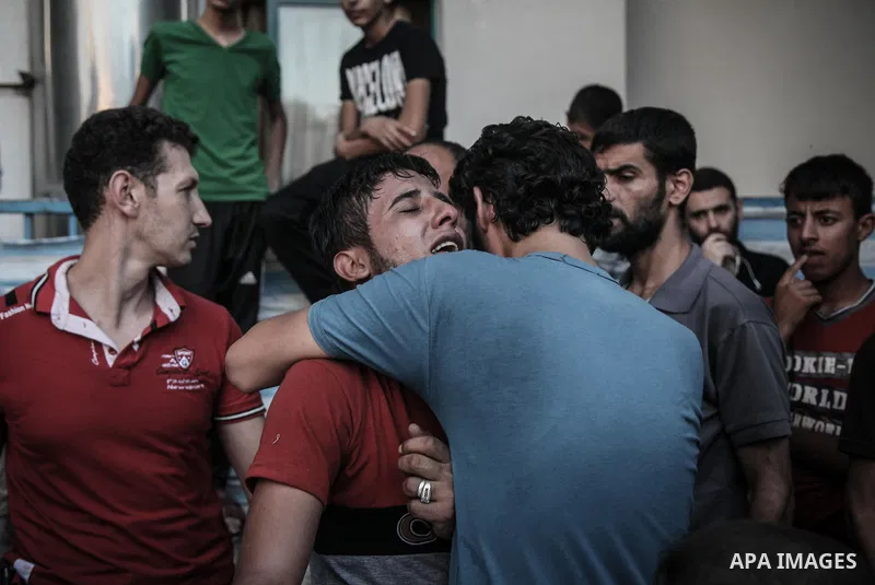 Palestinians cry after identifying their loved one, killed on an Israeli strike in Shijaiyah neighbourhood, at the morgue of Gaza City's Shifa hospital, Wednesday July 30, 2014. Israeli strikes hit the crowded shopping a...