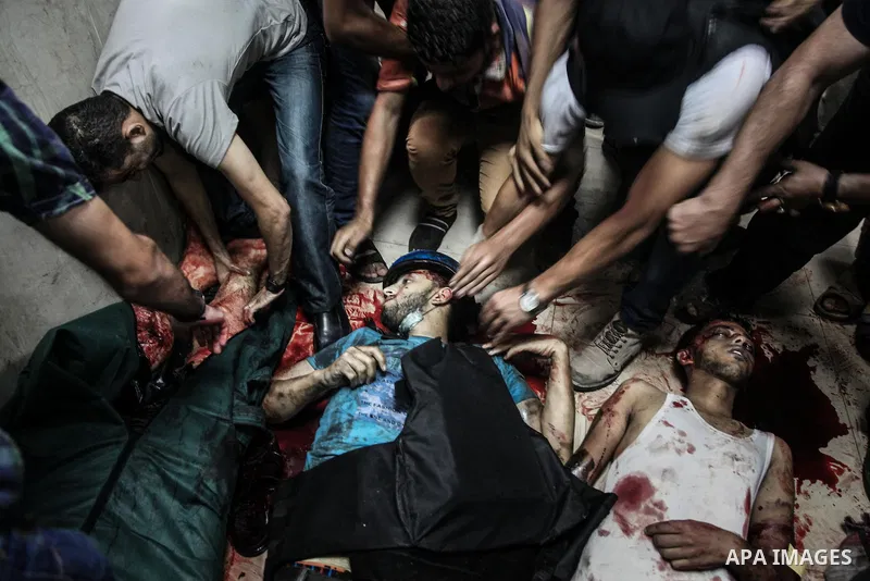 Palestinians wheel the lifeless body of video journalist, Rami Rayan, following an Israeli Strike in Shijaiyah neighborhood, to the emergency room of the Shifa Hospital, in Gaza City, Wednesday, July 30, 2014.Photo by Ez...