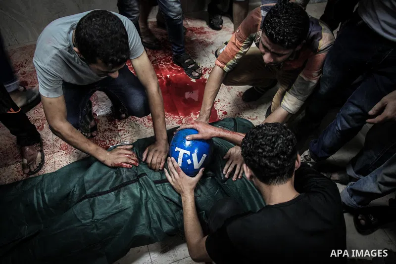 Palestinians wheel the lifeless body of video journalist, Rami Rayan, following an Israeli Strike in Shijaiyah neighborhood, to the emergency room of the Shifa Hospital, in Gaza City, Wednesday, July 30, 2014.Photo by Ez...