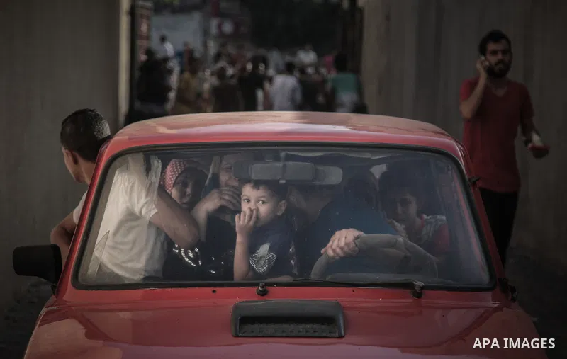 Palestinian families leave their apartments in El-Joundi tower to a safer location after Israeli strike in Gaza City, on, Wednesday July 30, 2014. Israeli strikes hit the crowded shopping area in Gaza City, hours after t...