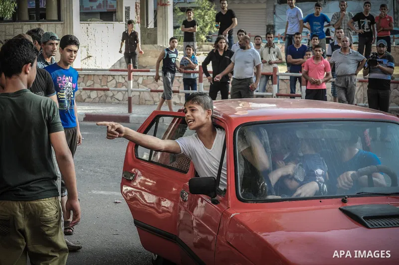 Palestinian families leave their apartments in El-Joundi tower to a safer location after Israeli strike in Gaza City, on, Wednesday July 30, 2014. Israeli strikes hit the crowded shopping area in Gaza City, hours after t...