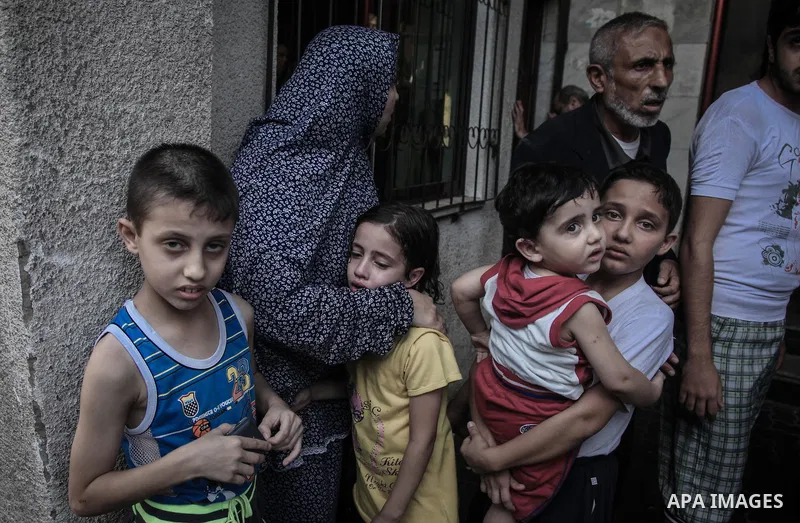 Palestinian families leave their apartments in El-Joundi tower to a safer location after Israeli strike in Gaza City, on, Wednesday July 30, 2014. Israeli strikes hit the crowded shopping area in Gaza City, hours after t...