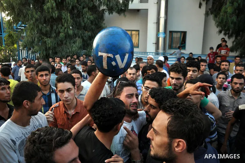 Palestinians carry the body of video journalist, Rami Rayan, following an Israeli Strike in Shijaiyah neighborhood, at Al-Shifa Hospital, in Gaza City, Wednesday, July 30, 2014. Photo by Mohammed Talatene
