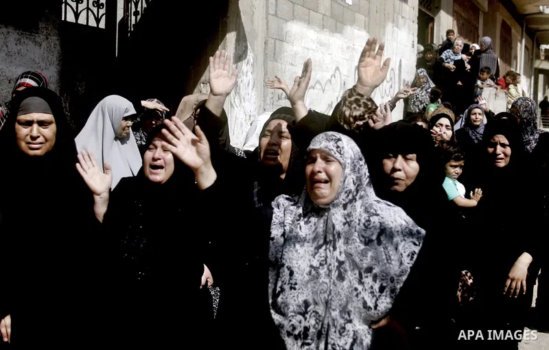 Palestinian relatives mourn on the bodies Palestinian killed in Israeli strike, during their funeral in Gaza city, July 30, 2014. Israeli bombardments early on July 30 killed "dozens" of Palestinians in Gaza, including a...