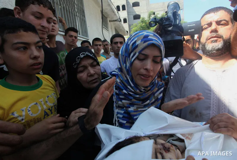The mother (2L) and aunt (C) of Palestinian girl, Layan al-Silk, mourn during her funeral in Gaza City on July 31, 2014. At least 10 people were killed in Israeli strikes on central and southern Gaza bringing the Palesti...